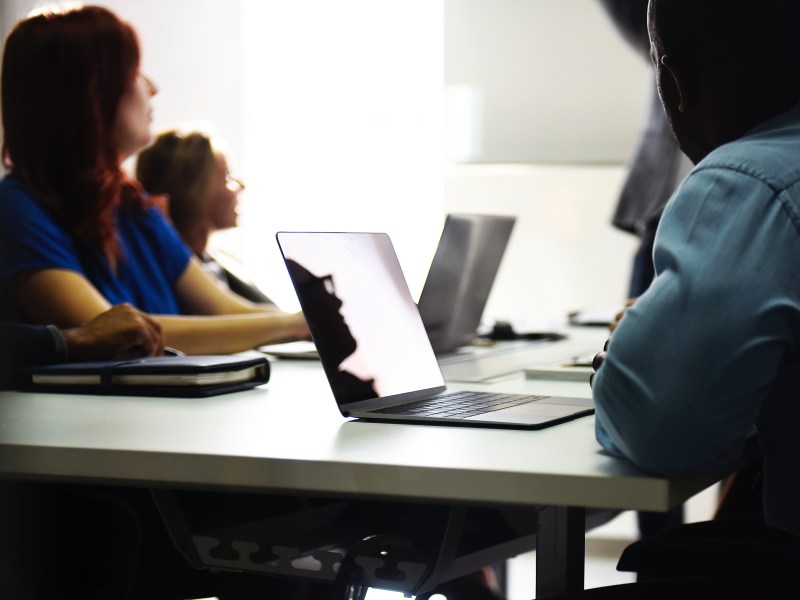 People at desk with laptops receiving classroom training