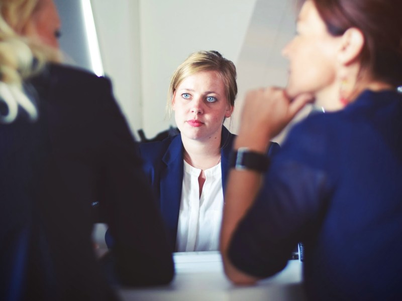 Three women at desk in business setting