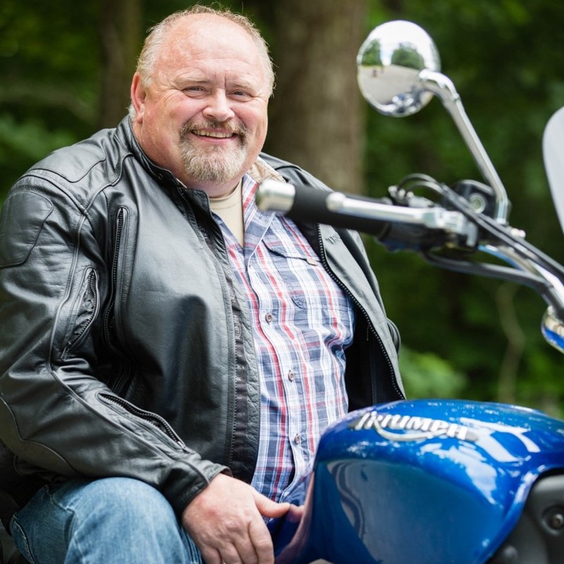 Shaun Drakeford, Owner of Back Roads Adventures, USA sitting on a motorcycle.