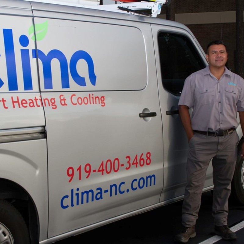 Jacob Sierra, owner of Clima Smart Heating & Cooling LLC, stands next to one of his service vehicles.